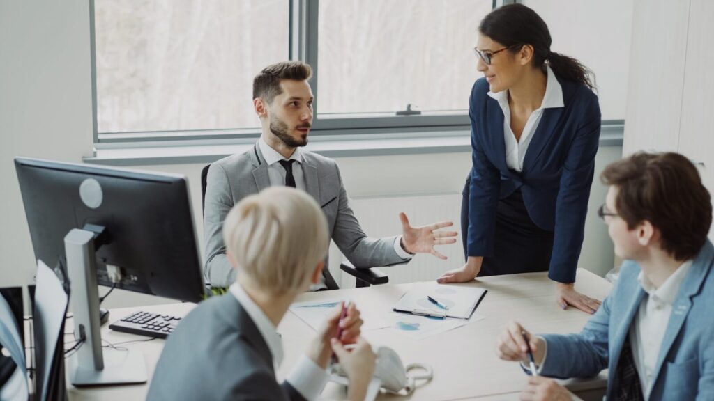 Des professionnels collaborent lors d'une réunion de bureau moderne.