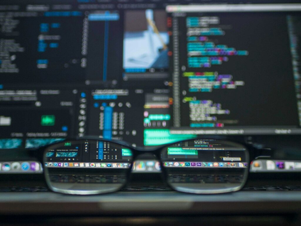 gros plan de lunettes sur fond de codage informatique